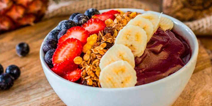 Tigela de açaí com granola, frutas e mel