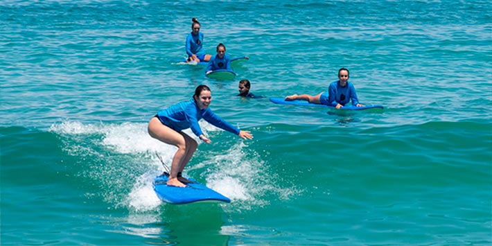 Grupo de surfistas pegando ondas em um Surf Camp